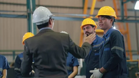 Man in white hard hat addresses group Stock Footage 341925369