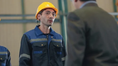 Man in white hard hat addresses group Stock Footage 341925383