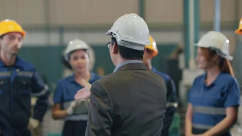 Man in white hard hat addresses group Stock Footage 341925406