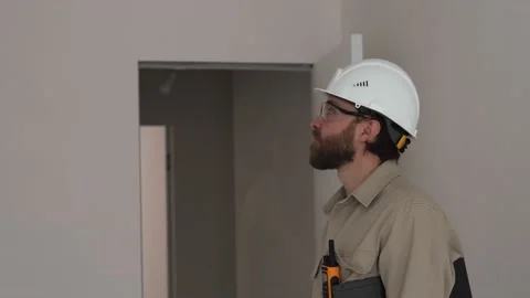 A man in a white helmet from the construction commission during work. Stock Footage 235543121
