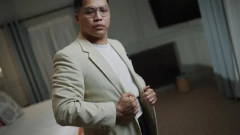 A man in a white jacket is adjusting his shirt Stock Footage 295996616