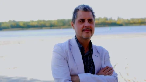 Man in a white jacket thought on the river bank Stock Footage 85619882
