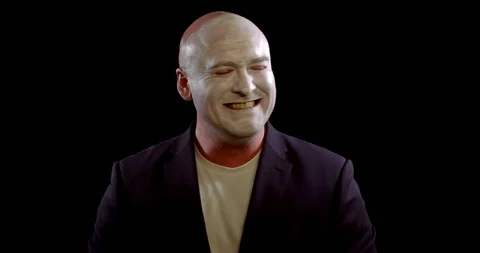 Man with white makeup on face is laughing like a joker in black background, evil Stock Footage 120023396