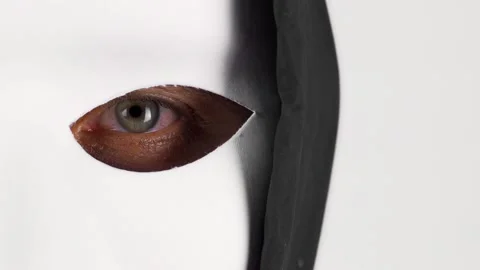 A man with a white mask on his face, looking directly at the camera Vídeos de archivo 133644698