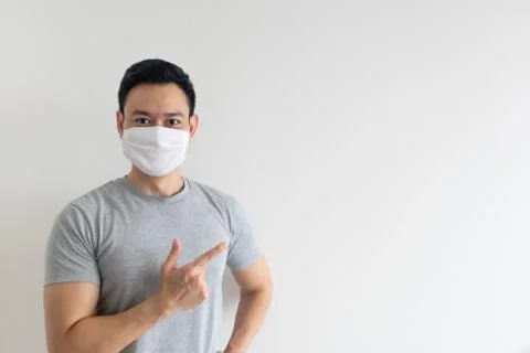 Man in white mask presenting the empty copy space on isolated background. Stock-Fotos