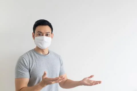 Man in white mask presenting the empty copy space on isolated background. Stockfoto's