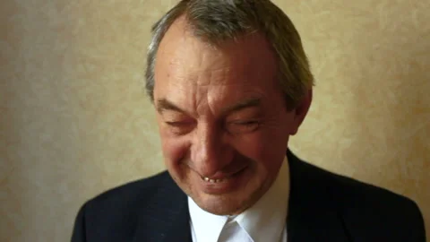The man in a white shirt and a jacket smiles, laughs. Video stock 86990163