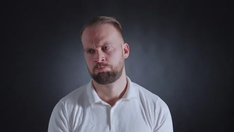 Man in white shirt with a beard, looking concerned. 库存影片 308073090