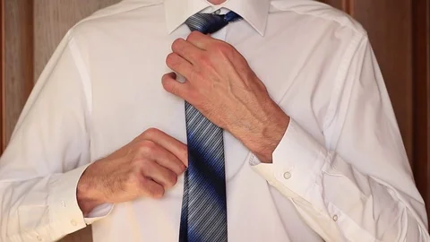 Man in white shirt correcting his necktie 스톡 동영상 70943053