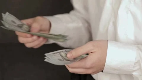 Man in white shirt counting dollars by hands. closeup of businessman hands Видео 336263130