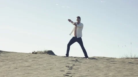 Man in a white shirt in the desert Stock Footage 78154341