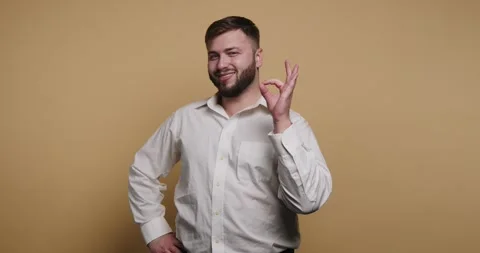 Man in white shirt performs a funny expression against a yellow background .. Видео 326797901