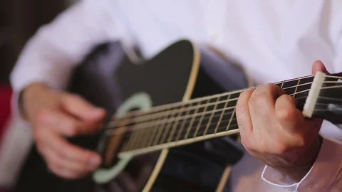 Man in white shirt playing classical guitar Stock Footage 76414625