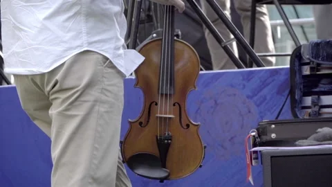 Man in white shirt putting a violin in it's case Stock Footage 277803053