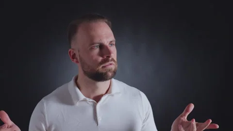 Man in white shirt, questioning expression, hands raised. Vidéo 308072958