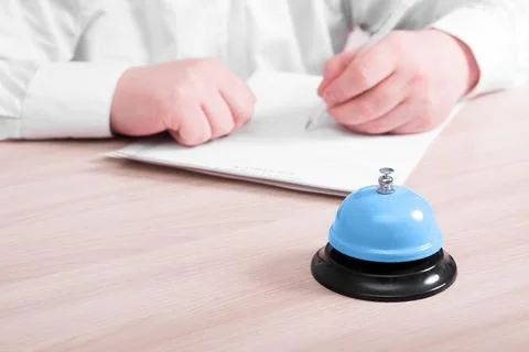 A man in a white shirt sits at a table and signs an employment contract, on t Stock Photos