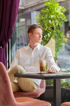 Man in a white shirt at a table in a cafe Stock Photos