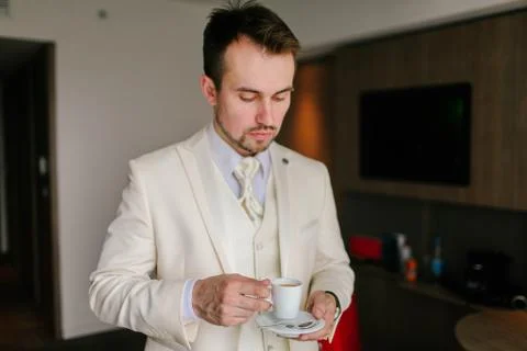 The man in the white suit drinking espresso Foto stock