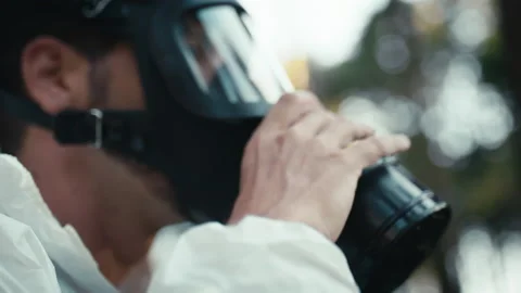 Man with white suit in the middle of the woods wears black gas mask Stock Footage 201635715