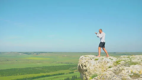 A man in white is training at the top of a mountain. Shadow fight in the 스톡 동영상 201304349