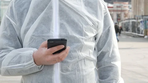 Man in white uses smartphone Stock Footage 129064709