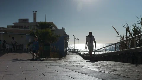 Man In White Walking On The Paved Seafront La Caleta Tenerife Spain Slow Motion Stock Footage 104395287
