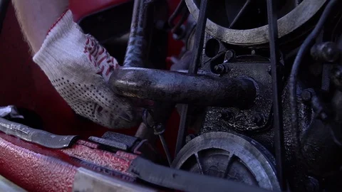 Man in white work gloves checks the oil in engine of old red retro car. Close up 库存影片 125959729