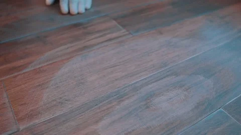 Man in white working glove wipe out laminate floor with wet cloth Stock Footage 74813600
