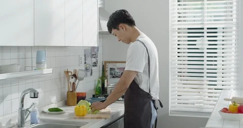 A man who cuts vegetables in the kitchen Stock Footage 100944071