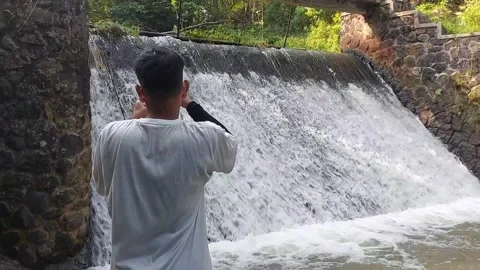 A man who is fishing using a casting technique in a river Stock Footage 280309968