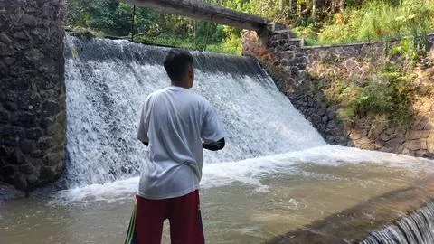 A man who is fishing using a casting technique in a river Stock Photos