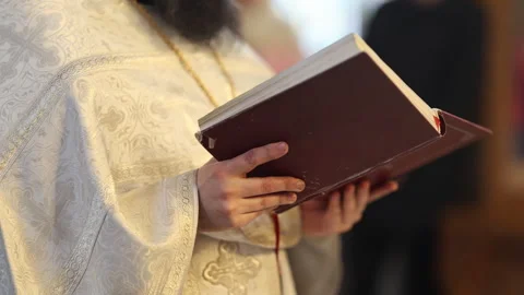 A man who has a beard is peacefully reading a bible in a church Stock Footage 307301903