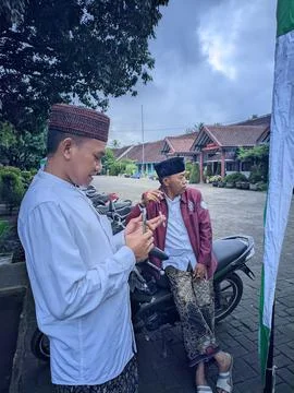 The man who is taking pictures using his smartphone camera is wearing local.. Foto stock
