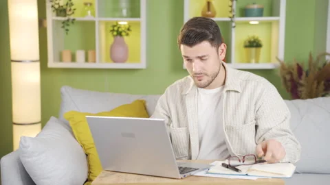 The man, whose eyes hurt from working, takes off his glasses and starts rubbing  Stock Footage 232226320