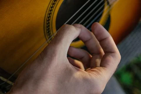 A man, whose face is not visible, plays the guitar on a musical instrument, s Foto stock