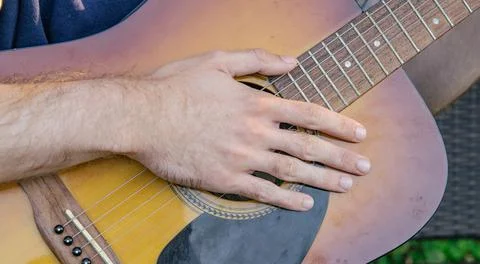 A man, whose face is not visible, plays the guitar on a musical instrument, s Foto stock