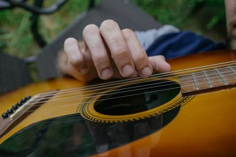 A man, whose face is not visible, plays the guitar on a musical instrument, s Foto stock