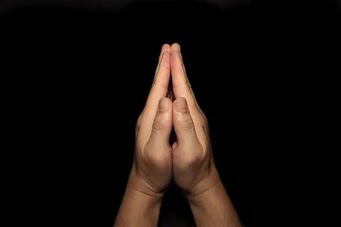 The man whose hand is praying on the black background Stock Photos