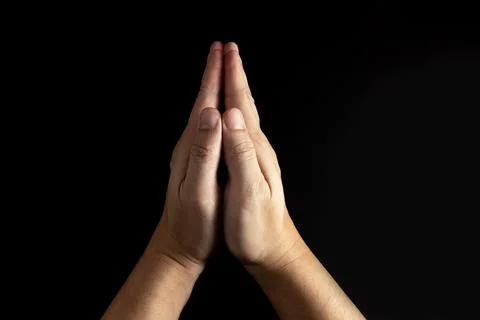 The man whose hand is praying on the black background Stock Photos