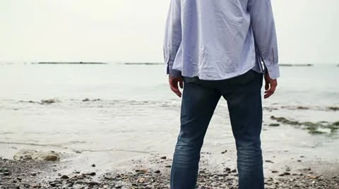 Man with wide open arms standing on the beach, steadicam shot HD Stock Footage 10860122
