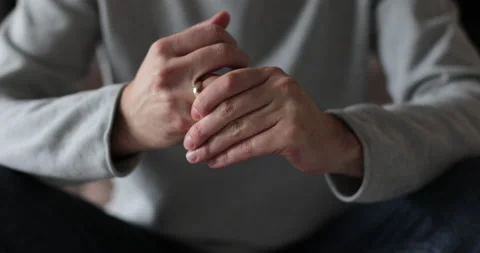 Man wiggles his wedding ring on his finger. Man suffering from emotional pain. Video stock 302262122