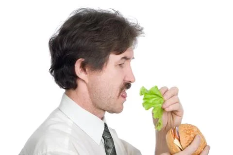 Man will get from hamburger sheet salad and eats Stock Photos