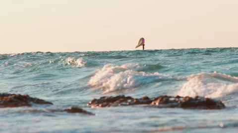 man is wing foiling using handheld inflatable wings and hydrofoil surfboards Stock Footage 289805332