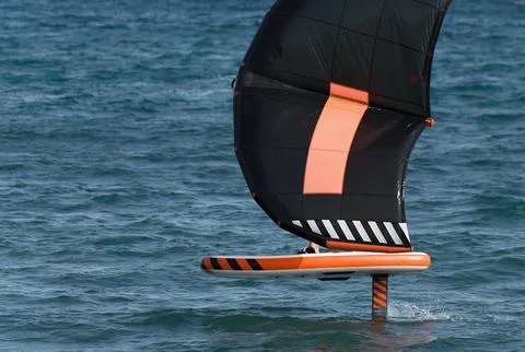 A man is wing foiling using handheld inflatable wings 스톡 사진