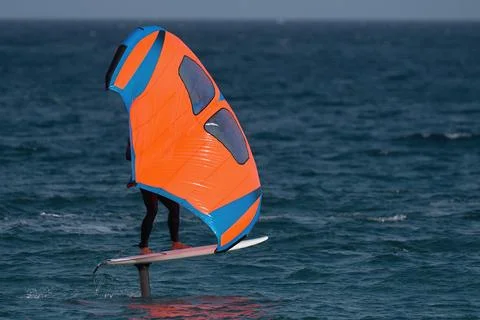 A man is wing foiling using handheld inflatable wings Stock Photos