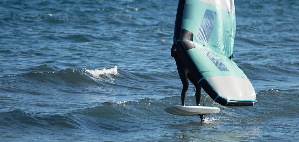 A man is wing foiling using handheld inflatable wings 스톡 사진