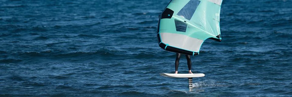 A man is wing foiling using handheld inflatable wings 스톡 사진