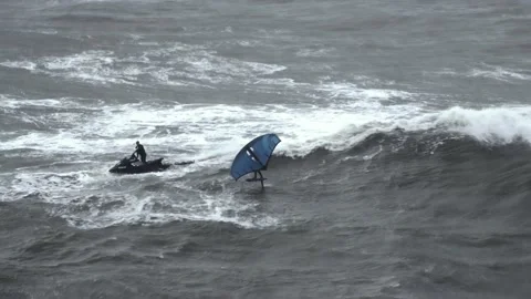 A man on a wingboard battles Big waves of the Atlantic Ocean. Stock Footage 230893027