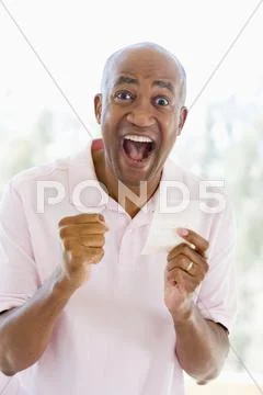 Man with winning lottery ticket excited and smiling Stock Photos