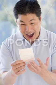 Man with winning lottery ticket excited and smiling Stock Photos
